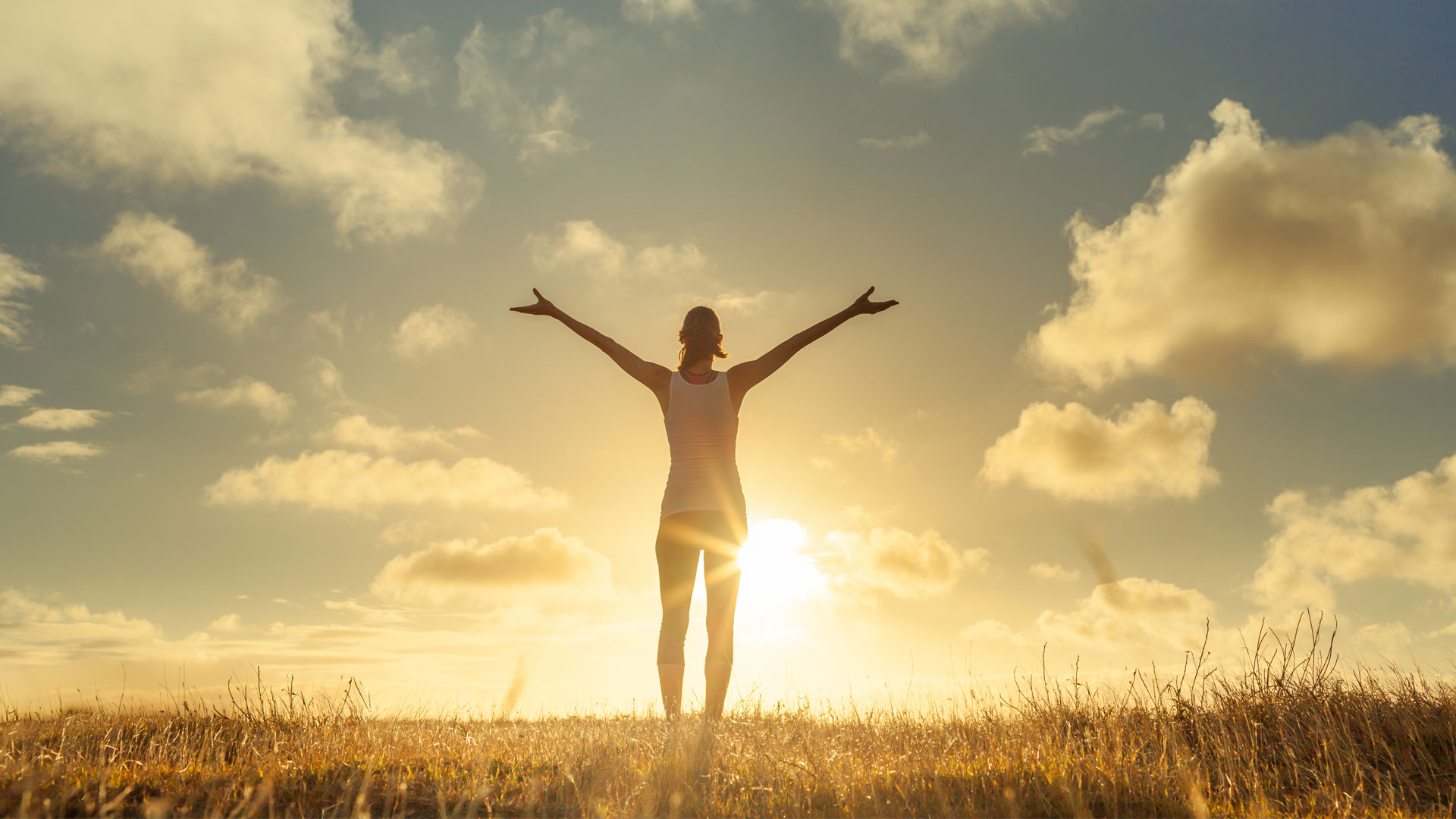 women celebrating freedom in a grassy field on a clear sunny day